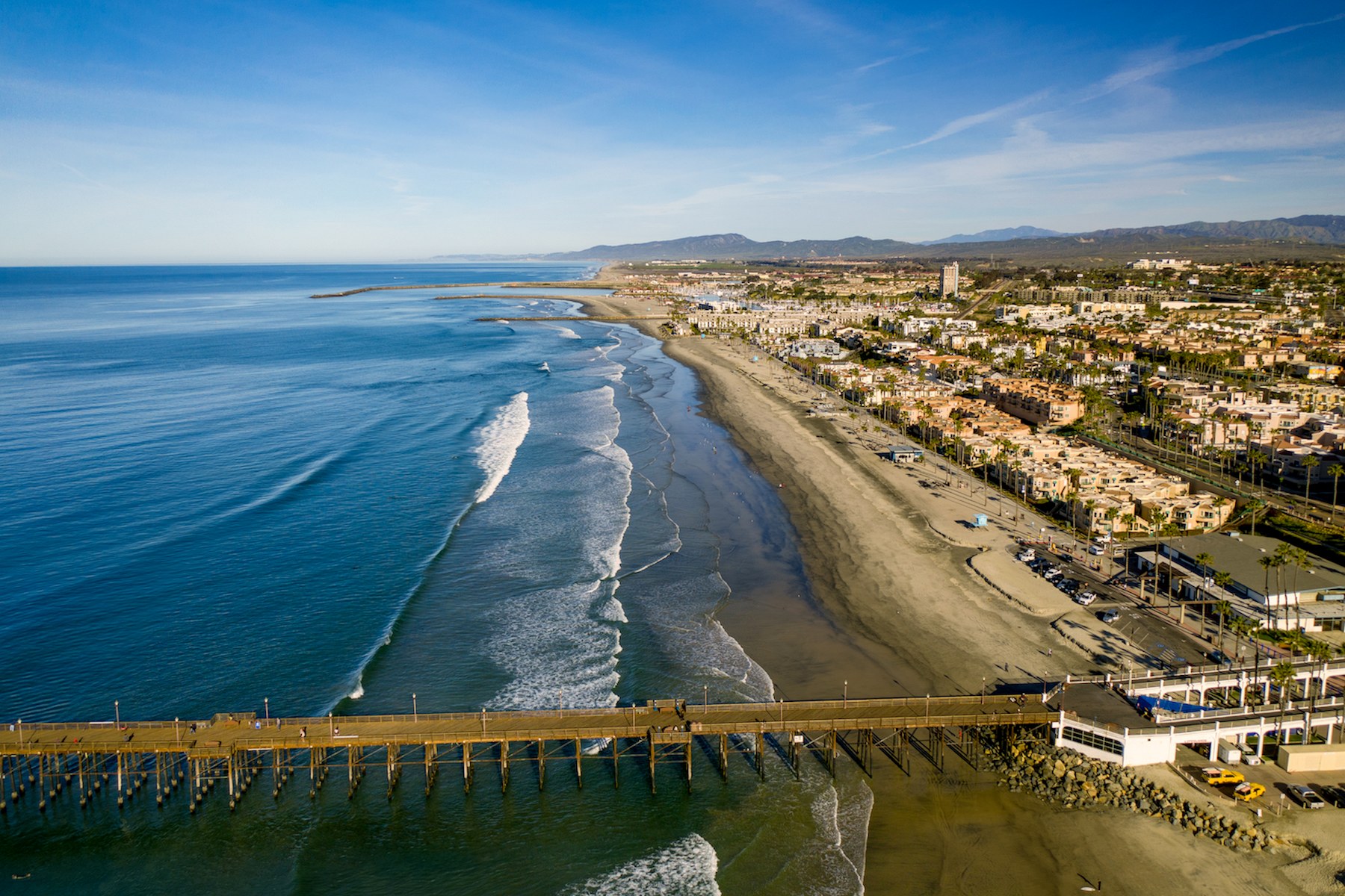 Aerial view of the Oceanside coastline, beach, pier, and surrounding community
